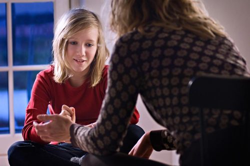 Portrait of a teenage girl talking to her mother or counsellor