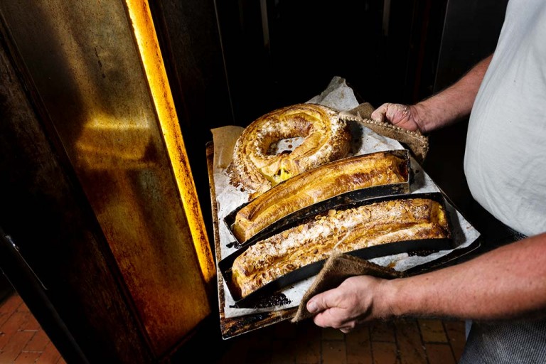 Baker with a selection of danish pastries coming out of the oven