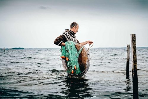 Shrimp fisherman putting out his nets