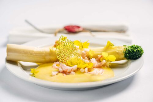 Hvide asparges med hollandaise sauce, rejer og rapsblomster.