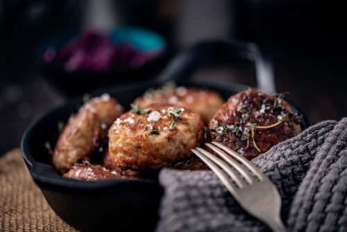 Close-up of a bowl of freshly made, pan fried frikadeller.