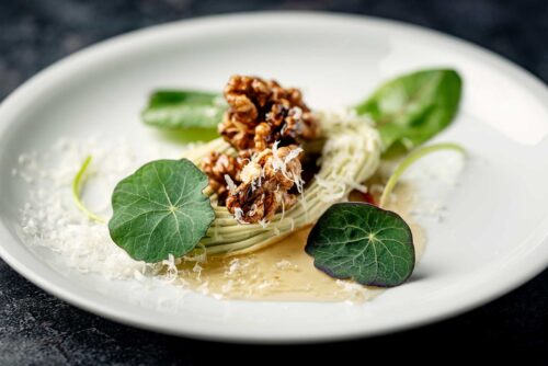 Dish of blue cheese mousse with parmesan, walnuts witha honey glaze and fresh peppery nasturtium leaves.