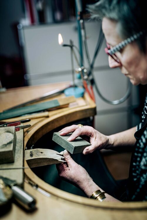 A Goldsmith skilled hands at work as she carefully applies the finishing touches to a silver ring.