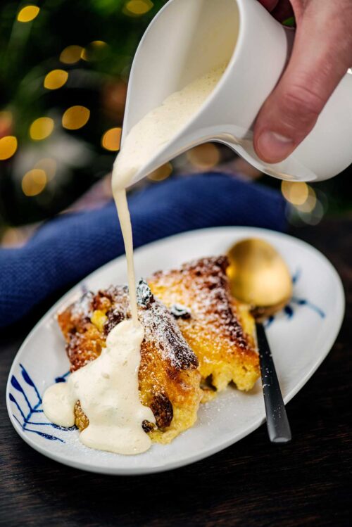 Bread and butter with cream being poured over it.