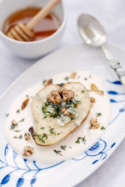 Baked pear with cheese, walnuts and fresh thyme with a honey dressing.