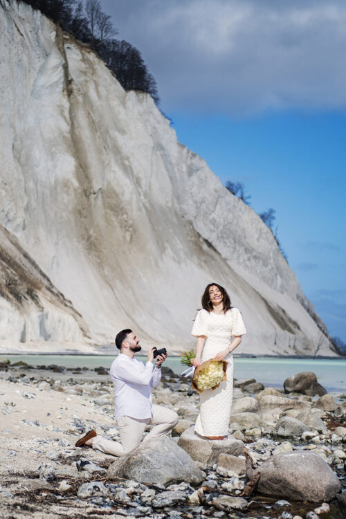 Forlovelsesfotografering ved de hvide klinter på Møns Klint – kvinde med blomsterbuket foran havet.